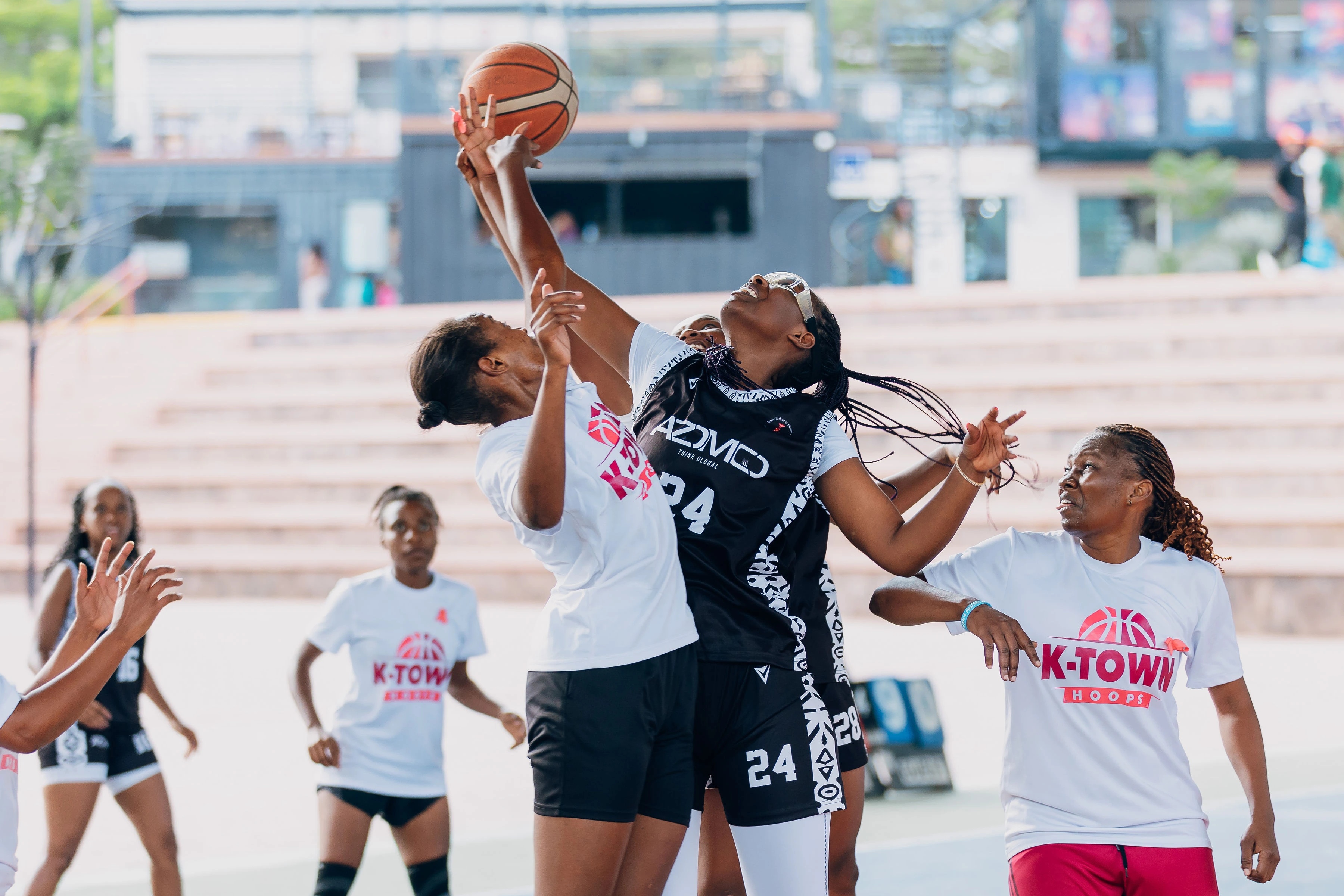 Basketball action under the roof of Zaria Court, with supporters seated courtside
